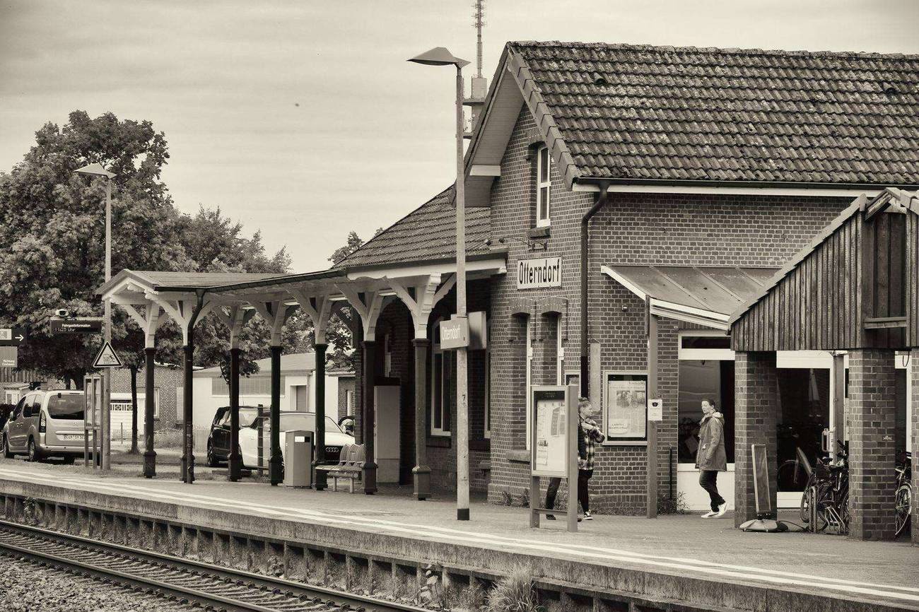 Bahnhof Otterndorf: Backsteingebäude mit Bahnsteigüberdachung, Bahnschild „Otterndorf