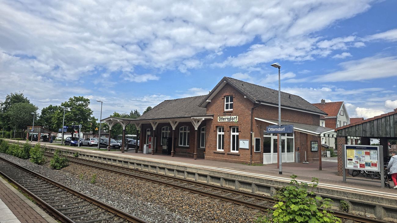 Backsteingebäude des Bahnhofs Otterndorf mit überdachtem Bahnsteig und Schild „Otterndorf