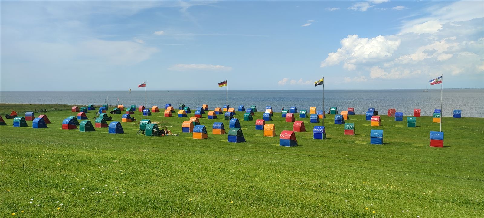 Bunte Strandkörbe auf dem Deich in Otterndorf mit Blick auf die Elbe