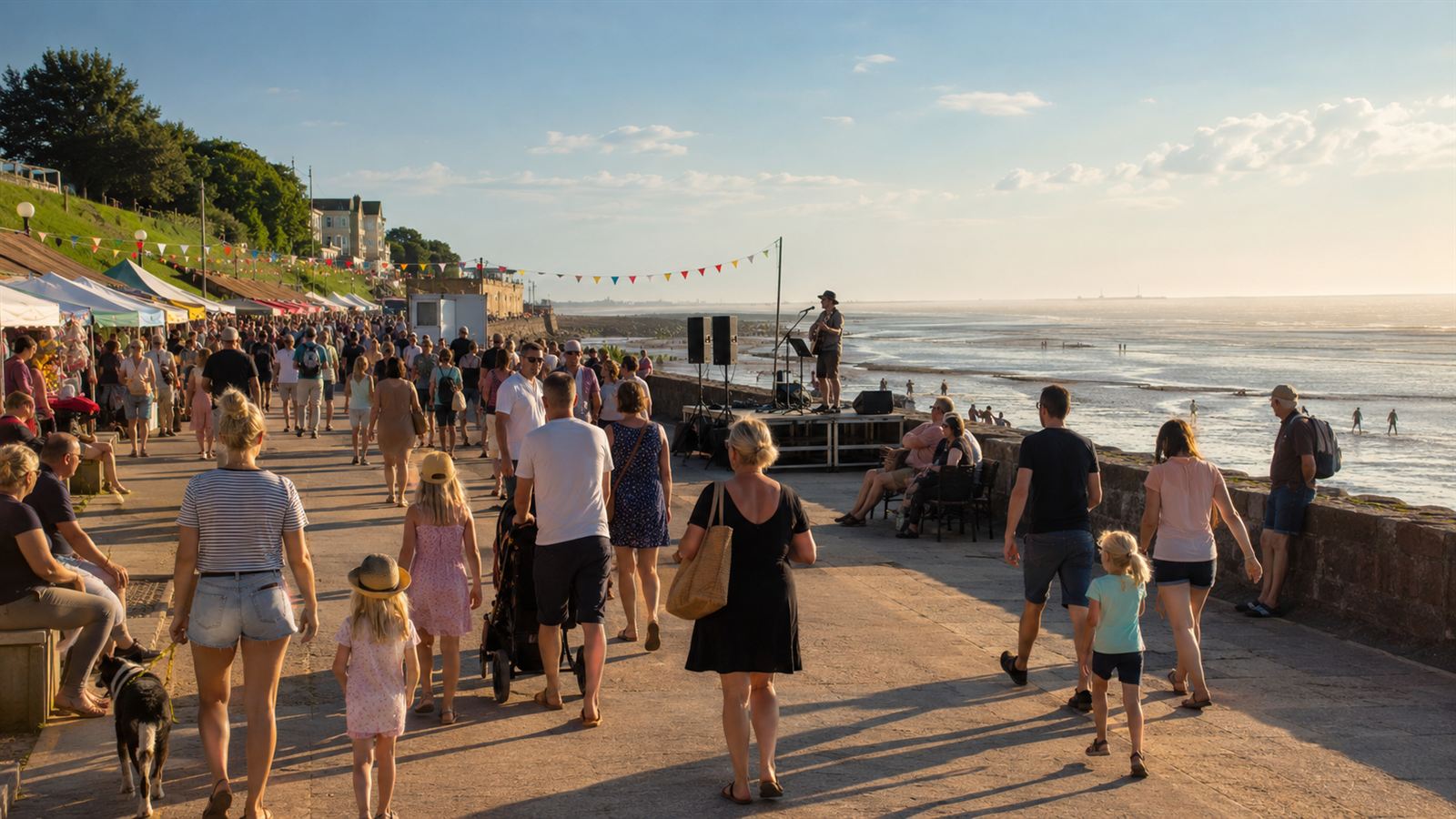 Belebte Strandpromenade in Cuxhaven-Duhnen mit Straßenkünstlern und Besuchern bei Sommerwetter am Meer