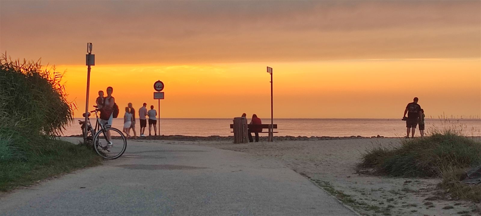 Sonnenuntergang am Otterndorfer Strand – Menschen am Deich, Fahrrad, orangefarbener Himmel