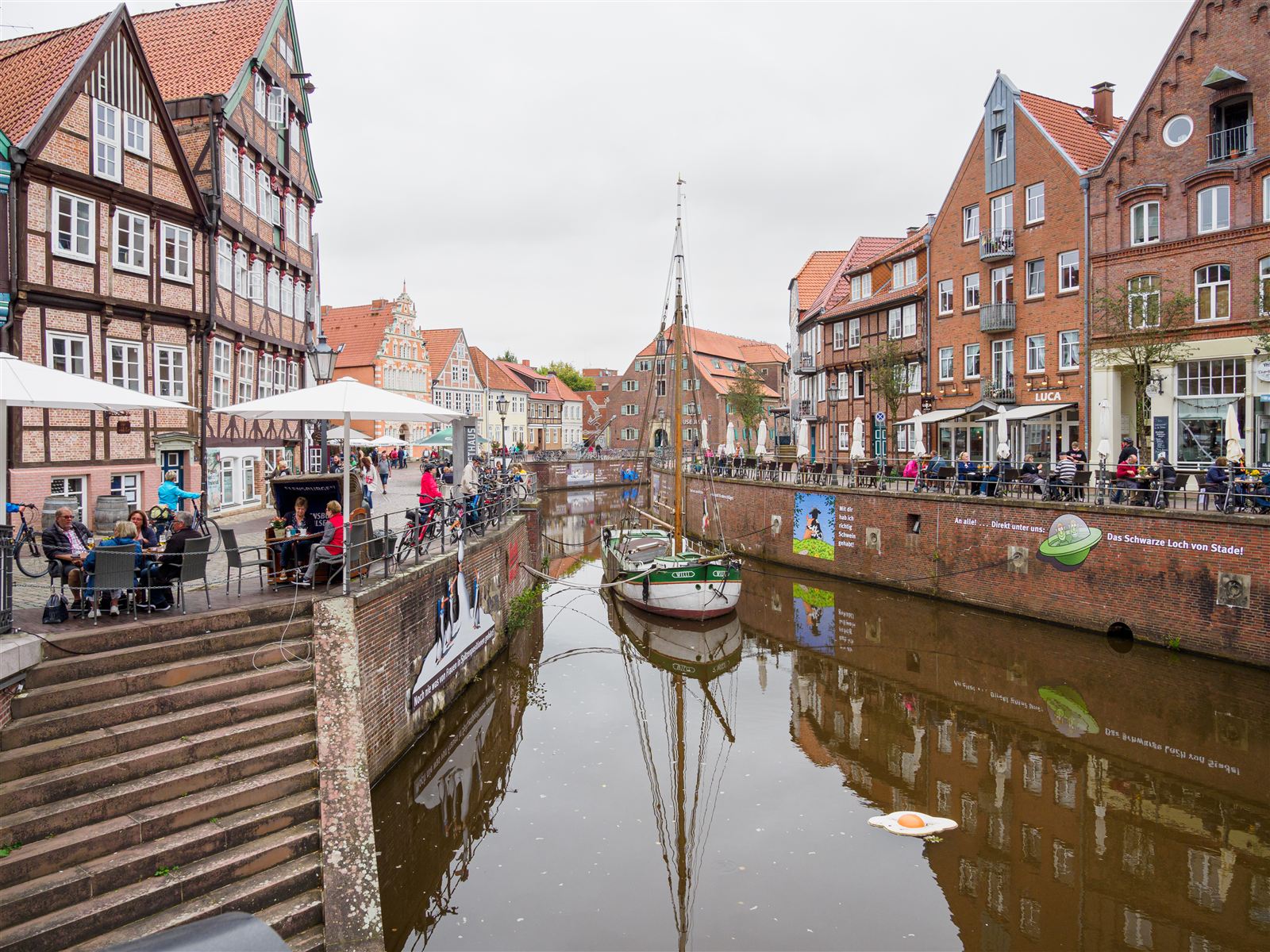 Historischer Hansehafen in Stade mit Fachwerkhäusern und altem Holzkran am Wasser